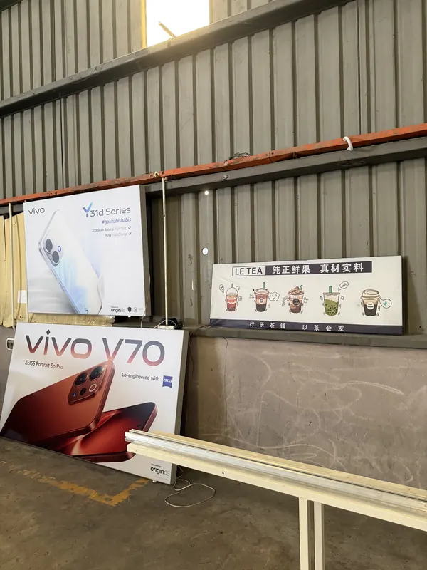Phone-brand display panels and a drinks-shop board, waiting for delivery.